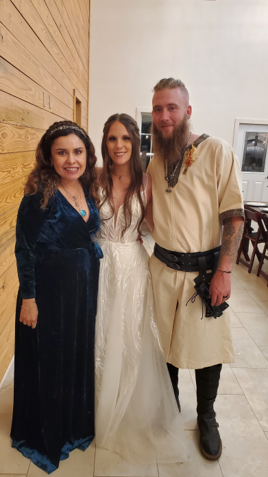 Wedding oficiant portrait with Viking bride and groom in traditional-inspired attire